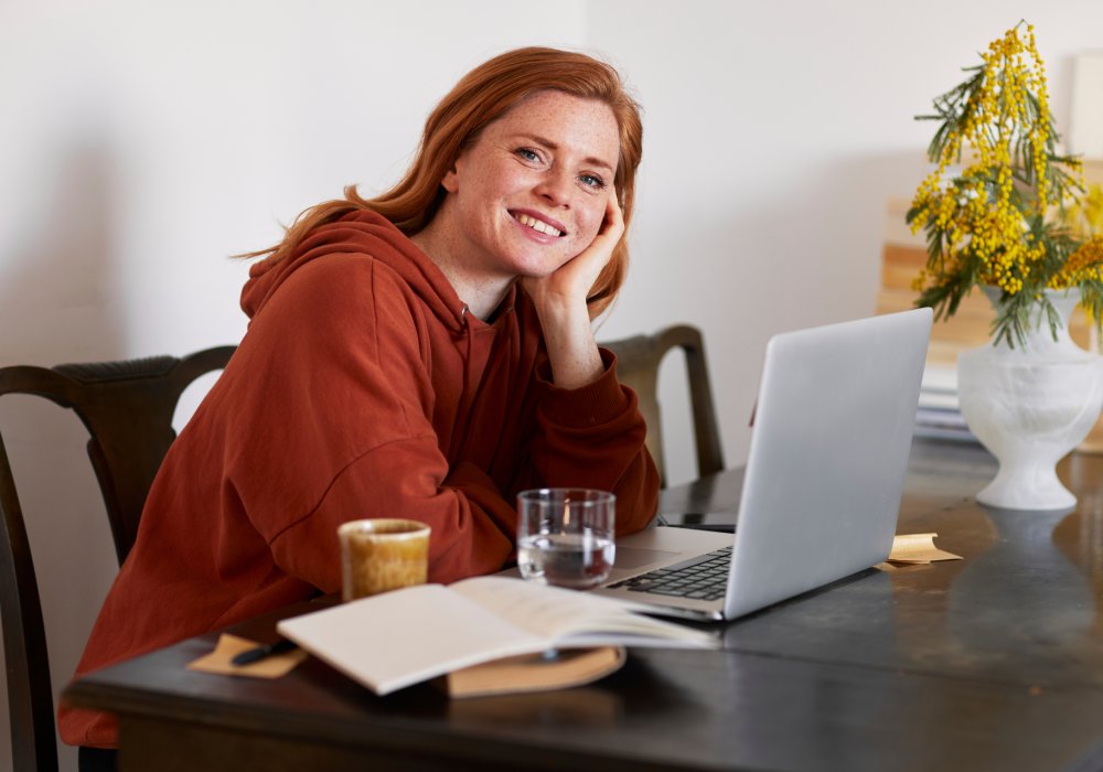 Dame som sitter ved spisebordet med en pc, illustrasjonsfoto/stockfoto