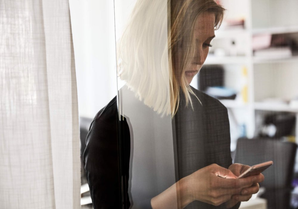 Illustrasjonsfoto av kvinne som ser på telefonen sin