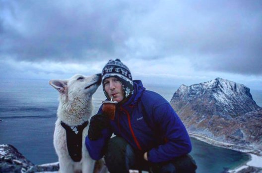 Erlend Hunstad på en fjelltopp sammen med hunden sin.