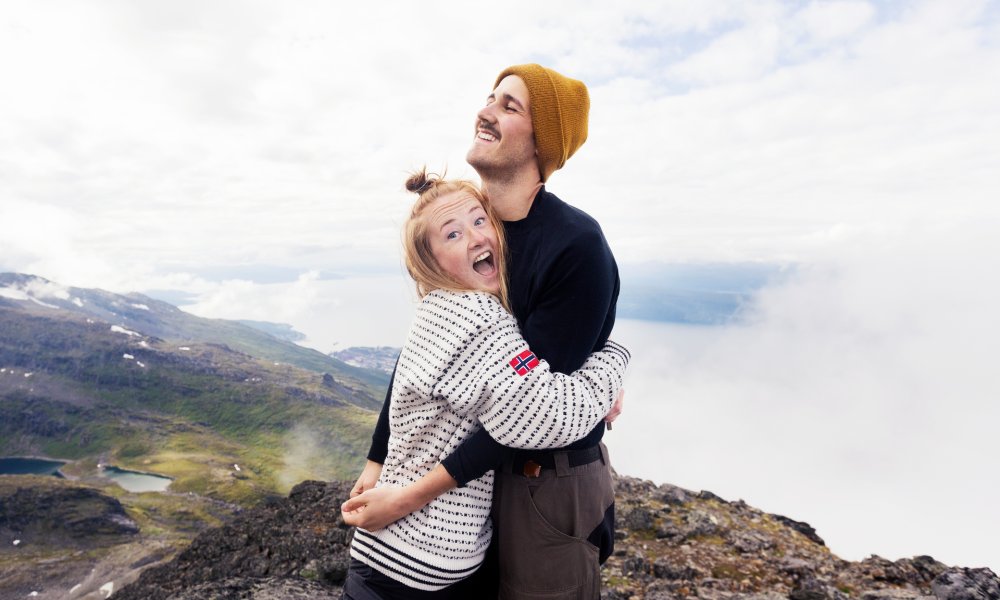 Illustrasjonsfoto: Et ungt par omfavner hverandre på toppen av et fjell.